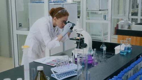 Scientist Using Microscope in Brightly Lit Laboratory