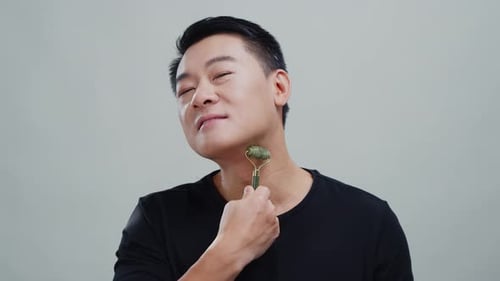 Man Uses Jade Roller on Neck for Beauty