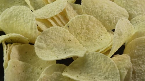 Close up potato chips spinning background. Snack for drinks. Golden fried potatoes. Crispy snacks