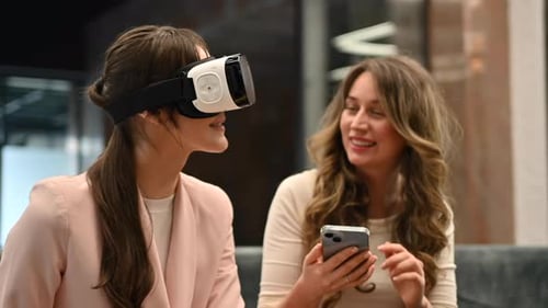 Happy woman working with VR virtual reality set on head at the office