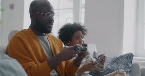 Father and Child Play Video Game Together at Home