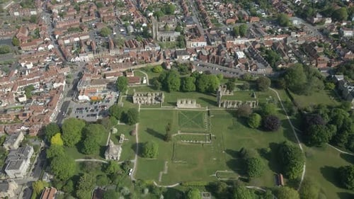 Aerial view of the Glastonbury Abbey ruins an 8th century monastery and gardens. Drone moving backwa
