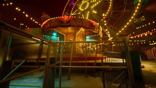 Empty Amusement Park at Night with Illuminated Rides and Colorful Lights