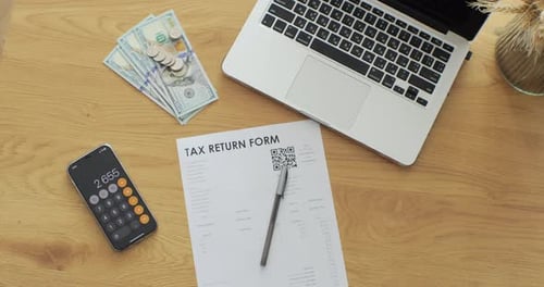 Shot of Table with Tax Return Paper Forms Laptop and Phone with Calculator for Counting Annual