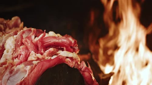 Close Up of Raw Meat Grilling Over Flames