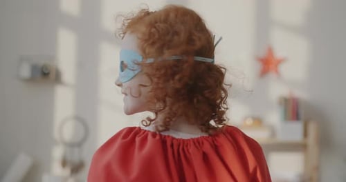 Child in Superhero Costume Smiling Indoors