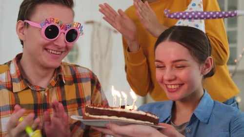 Friends Celebrate Birthday with Cake and Party Blowers