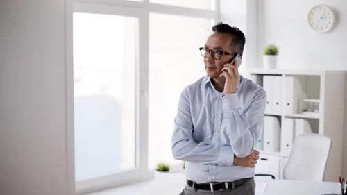 Man in Office Speaking on Smartphone