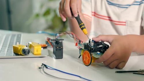 Child Engineering a Robot Car at Home