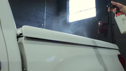 Car Detailer Sprays a Special Liquid on Car Surface Professional Vehicle Body Detailing Shop