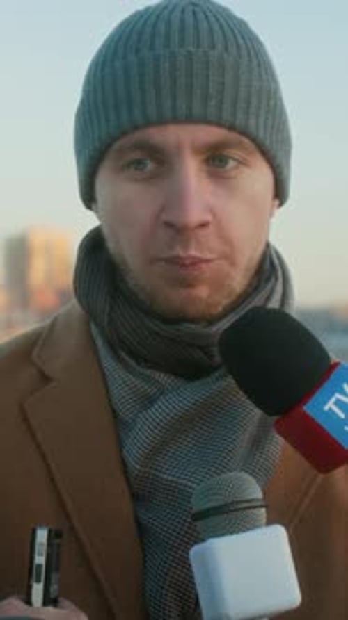Man Interviewed by Microphones on a City Street