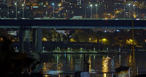 Night City Bridge Over the River Timelapse Los coches de transporte urbano salen por la noche con los faros encendidos