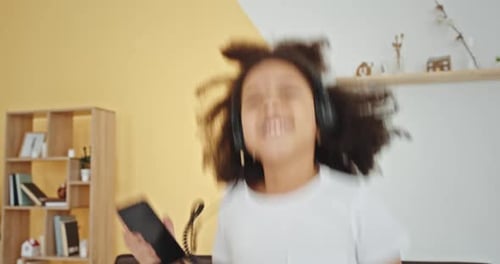 Energetic Child Dancing with Music Headphones and Phone