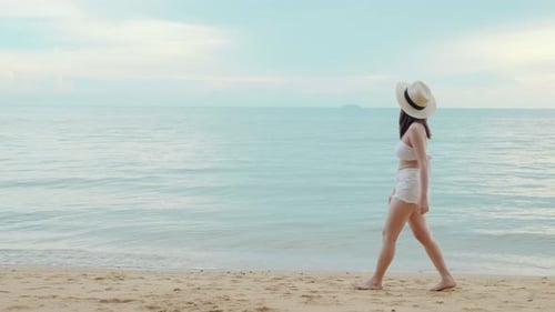 Woman Wear Sungrass and Sunhat Relaxing Walking at Tropical Paradise Beach