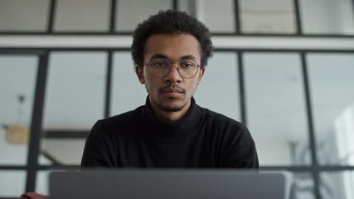 Focused Man Working on Laptop in Modern Office