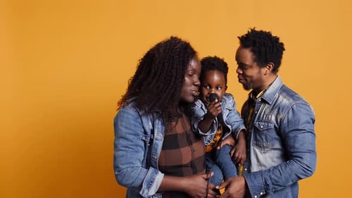 Joyful Family Sings Together into Microphone on Yellow Background