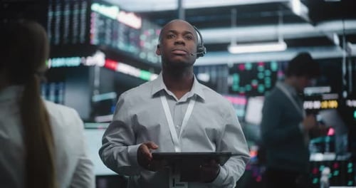 Experienced Financial Analyst Stands in Modern Trading Center