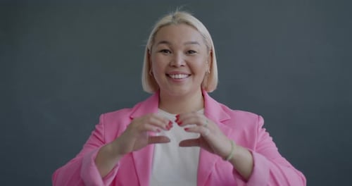 Smiling Woman Making Heart Shape With Hands