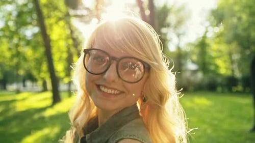 Jeune fille charmante aux cheveux blonds flirte et sourit un jour d'été
