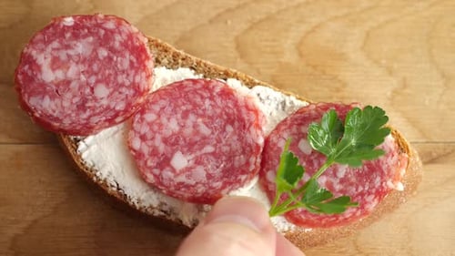 Preparing Salami Sandwich with Cheese and Herbs