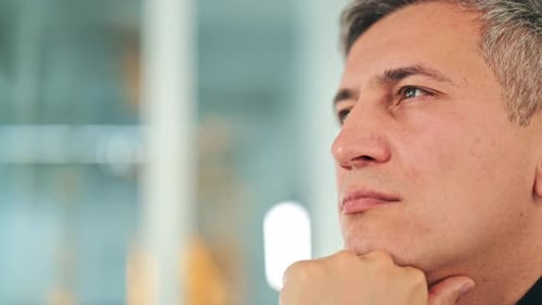 Thoughtful Businessman Listening Attentively in Modern Office