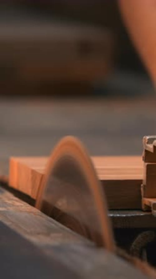 Expert Cabinetmaker Delicately Controlling Grain And Dust While Operating Spinning Blade In Workshop