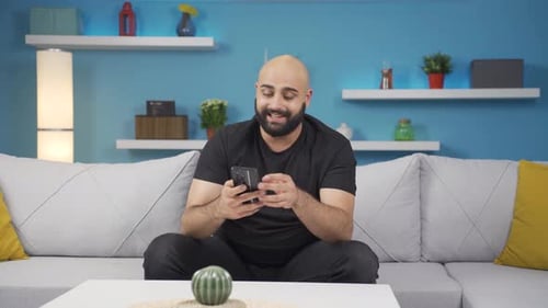 Man laughing at phone message.