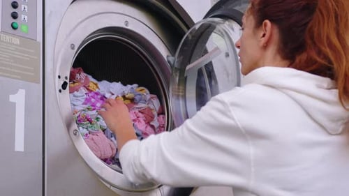 Woman Unloading Clothes from Commercial Washing Machine