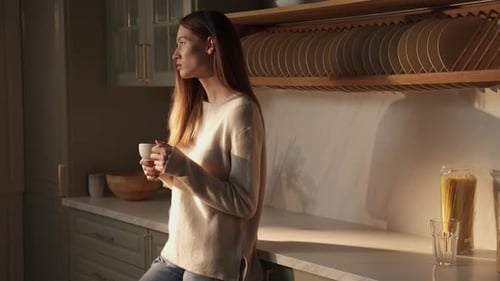 Pensive Woman Enjoying Morning Coffee in Kitchen