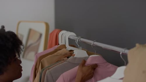 Woman Choosing Clothes on Rack in Bedroom