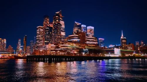 Long pier with bare trees and boats nearby. Boat travel around stunning New York at night.