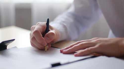 Signing a Document on a White Piece of Paper