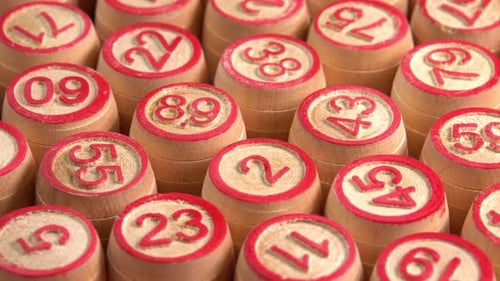 Lotto board game with wooden barrels with numbers rotate background in macro side view. Bingo game