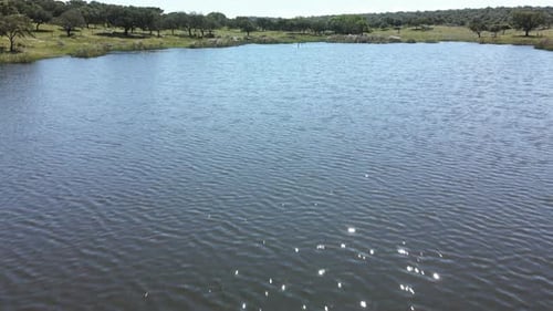 4K drone footage of a river near a green field
