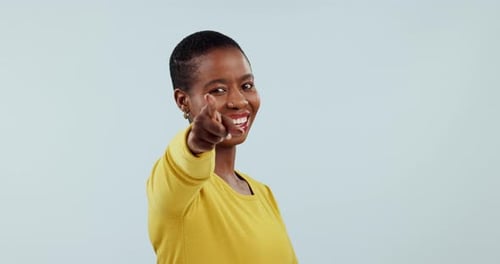 Lächle, habe die Wahl und zeige auf dich mit einer schwarzen Frau im Studio auf grauem Hintergrund, um zu wählen
