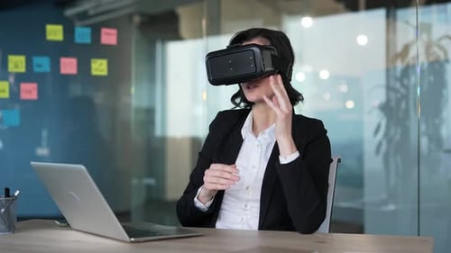 Businesswoman wearing VR headset in office exploring virtual reality technology.