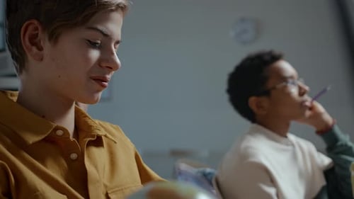 Teens Learning Together in Classroom Mid-Shot