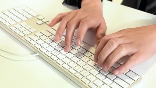Hands Typing on Modern Computer Keyboard at Desk