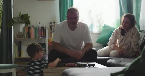 Family Playing with Toy Train in Living Room