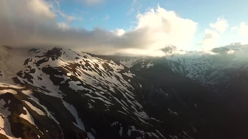 Aerial view of austrian mountains snowy peaks touching the clouds