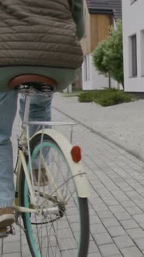 Vertical of Girl Riding Bike on Sidewalk in Neighbourhood