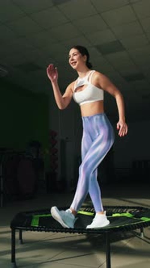 Young Woman Exercising on Mini Trampoline in Gym