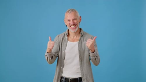 Joyful Man with Gray Hair Shows Thumbs Up and Supports