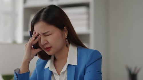 Businesswoman is seriously stressed working feel eye ache headache due to office syndrome.