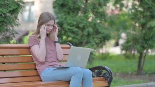 Woman Using Laptop on Park Bench