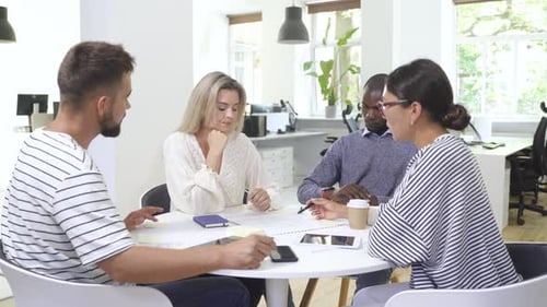 Colleagues Collaborating Around Table in Modern Office