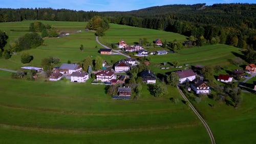 Small, quaint village nestled in a lush green valley, with a winding river snaking through the