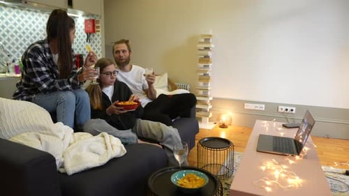 Young Adults Sharing Drinks and Snacks on Couch