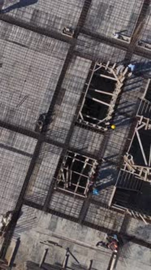 Vertical Video Aerial View of Workers Preparing Concrete Floor Framework With Scaffolding on a