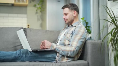 Handsome bearded young man remote meeting via webcam works using laptop computer. Caucasian male